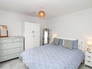 a bedroom with a bed and a dresser and a mirror at The Milk Shed in Plymtree