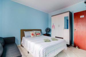 1 dormitorio con 1 cama y 1 silla negra en Casa da Cidinha en Extrema