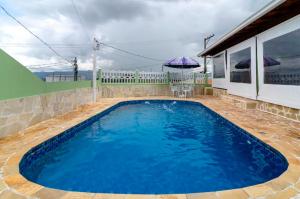 una gran piscina azul junto a una casa en Casa da Cidinha en Extrema