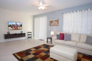 un soggiorno con divano bianco e ventilatore a soffitto di Stunning 5 Bd Home w/ Pool Close to Disney 4822 a Kissimmee