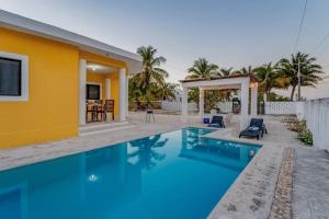 a villa with a swimming pool and a house at KIN House casa de playa con alberca in Telchac Puerto