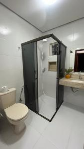 a bathroom with a shower with a toilet and a sink at casa temporada lua nova centro in Alto Paraíso de Goiás