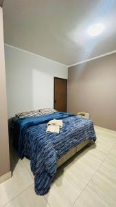 a bedroom with a bed with a blue comforter at casa temporada lua nova centro in Alto Paraíso de Goiás