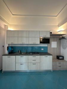 cocina con armarios blancos y suelo azul en De Riso Apartments Luxury Amalfi Coast, en Minori