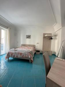 1 dormitorio con 1 cama y suelo de baldosa azul en De Riso Apartments Luxury Amalfi Coast, en Minori
