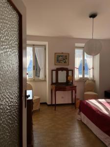 um quarto com uma cama, uma mesa e janelas em Terrazza sul lago em Ameno