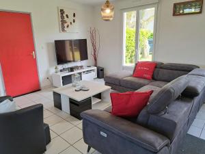 - un salon avec deux canapés et une télévision dans l'établissement Single storey holiday home near the beach, Santec, à Santec