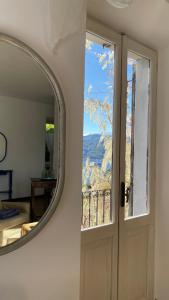 einen Spiegel neben einer Tür mit einem Fenster in der Unterkunft Balconata sul lago in Ameno