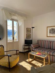 ein Wohnzimmer mit einem Sofa und einem Tisch in der Unterkunft Balconata sul lago in Ameno