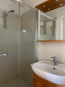 ein Bad mit einem Waschbecken und einer Glasdusche in der Unterkunft Balconata sul lago in Ameno