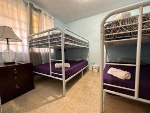 a bedroom with two bunk beds and a lamp at Cepeda Economical 10 BR Compound in San Juan