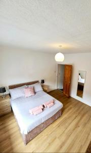 a bedroom with a bed with two pink towels on it at Comfortable 2 Bed House Near City Centre and M1 in Leicester