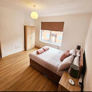 a bedroom with a large bed and a window at Comfortable 2 Bed House Near City Centre and M1 in Leicester
