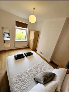 a bedroom with a large bed with two pillows on it at Comfortable 2 Bed House Near City Centre and M1 in Leicester