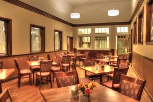 un restaurante con mesas y sillas de madera y ventanas en Hassayampa Inn, en Prescott