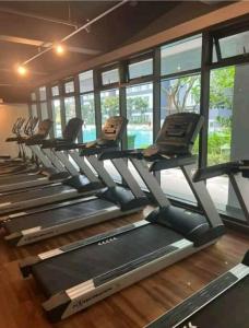 une rangée de tapis de course dans une salle de sport avec fenêtres dans l'établissement B2U Residensi Rimbun Kajang 2 Bedrooms, à Kajang