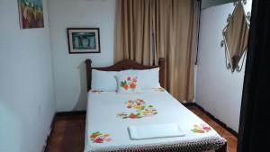 um quarto com uma cama branca com flores em HOTEL NEIVA REAL em Neiva