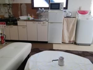 kuchnia z białymi urządzeniami i stołem w pokoju w obiekcie Corpo Marika 0 w mieście Hakodate
