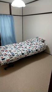 une chambre avec un lit avec une couette dessus dans l'établissement Corpo Marika 0, à Hakodate