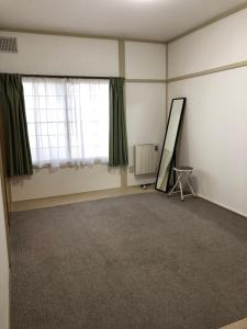 pusty pokój z lustrem i oknem w obiekcie Corpo Marika 0 w mieście Hakodate