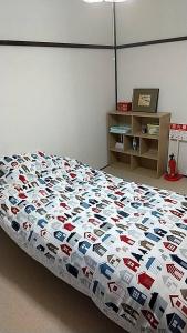 1 dormitorio con cama con edredón en Corpo Marika 0 en Hakodate