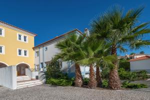 a pair of palm trees in front of a house at Casa do Fotógrafo in Sintra