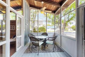 a screened porch with a table and chairs and windows at Ann Acres 21039 Elizabeth Ave in Rehoboth Beach