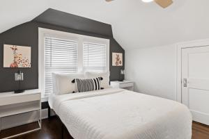 1 dormitorio con cama blanca y pared de acento negro en Chic Industrial 3 Bdr Home With Game Room, en Ferndale