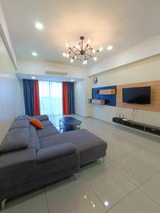 een woonkamer met een bank en een flatscreen-tv bij Joyful Sitiawan skygarden swimming pool in Seri Manjung