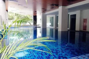 斯里曼绒Joyful Sitiawan skygarden swimming pool的一座蓝色瓷砖的游泳池