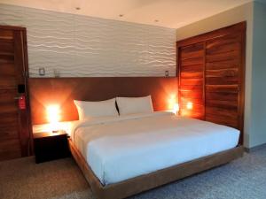 a bedroom with a large white bed with a wooden headboard at Grand Hotel Victoria in El Morro de Barcelona