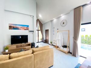 a living room with a couch and a tv at 286poolvilla in Suratthani