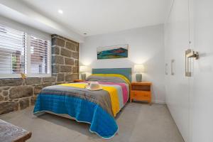 1 dormitorio con cama y pared de piedra en Steam Packet Wharf, en Port Fairy