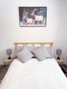 a bedroom with a bed with two deer paintings on the wall at Private Cottage with Huge Private Dog Park! in Barrys Bay