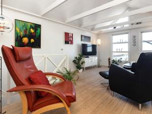 a living room with chairs and a couch and a television at Holiday home Nibe VII in Nibe