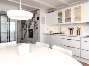 a kitchen with white cabinets and a white table and chairs at 5 person holiday home in Nibe-By Traum in Nibe +29 photos