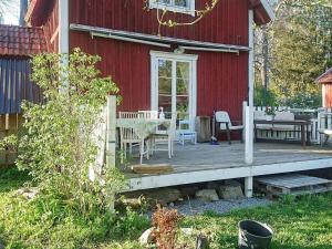 un porche de una casa roja con mesa y sillas en Holiday home Österhaninge, en Västerhaninge