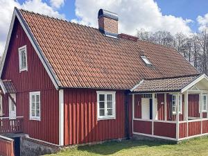uma casa vermelha com um telhado vermelho em Holiday home Ljungbyhed III em Ljungbyhed