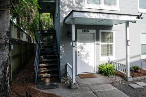 une maison blanche avec un escalier menant à une porte dans l'établissement Ricehope Place, à Charleston