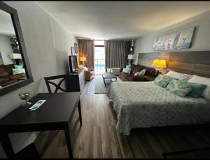 a hotel room with a bed and a living room at Upgraded Studio at Landmark Resort ! 17 pools, lazy rivers, jacuzzis! 814 in Myrtle Beach