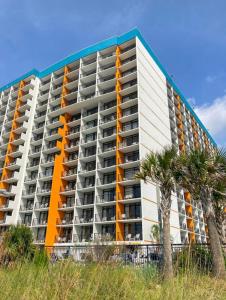 un edificio de apartamentos en la playa con palmeras en Upgraded Studio at Landmark Resort ! 17 pools, lazy rivers, jacuzzis! 814 en Myrtle Beach