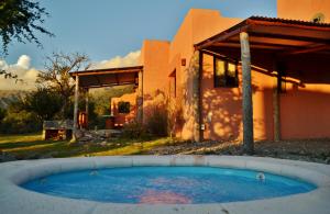 una pequeña piscina frente a una casa en Cabañas Chacras del Arroyo Vidal en Carpintería