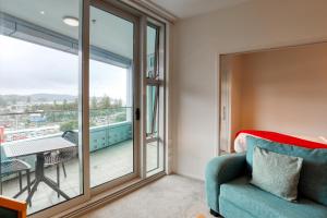 a living room with a couch and a large window at Marsden Suites Nautilus Orewa in Orewa