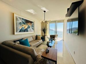 a living room with a couch and a table at Lujoso departamento frente al mar/camino al mar in Mazatlán