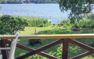 a view of a lake from a porch with a fence at Nice Home In Nykvarn With Wifi in Nykvarn +9 photos