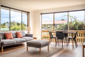 ビチェノにあるIsland Vista - Freycinet Holiday Housesのソファとテーブルと椅子のあるリビングルーム