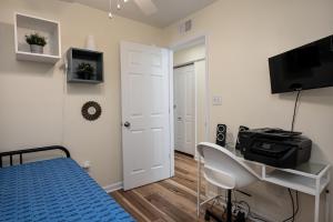 een slaapkamer met een bed, een bureau en een televisie bij Ricehope Place in Charleston