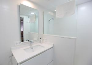 a white bathroom with a sink and a mirror at Albéniz in Córdoba