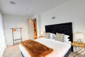 a bedroom with a large bed with a furry blanket on it at Marsden Suites Nautilus Orewa in Orewa