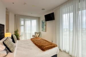 a bedroom with a bed with a brown blanket on it at Marsden Suites Nautilus Orewa in Orewa